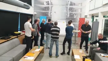Mistři společně pracují u flipchartu během workshopu
